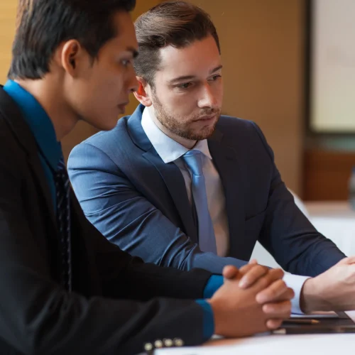 closeup two serious business men using tablet